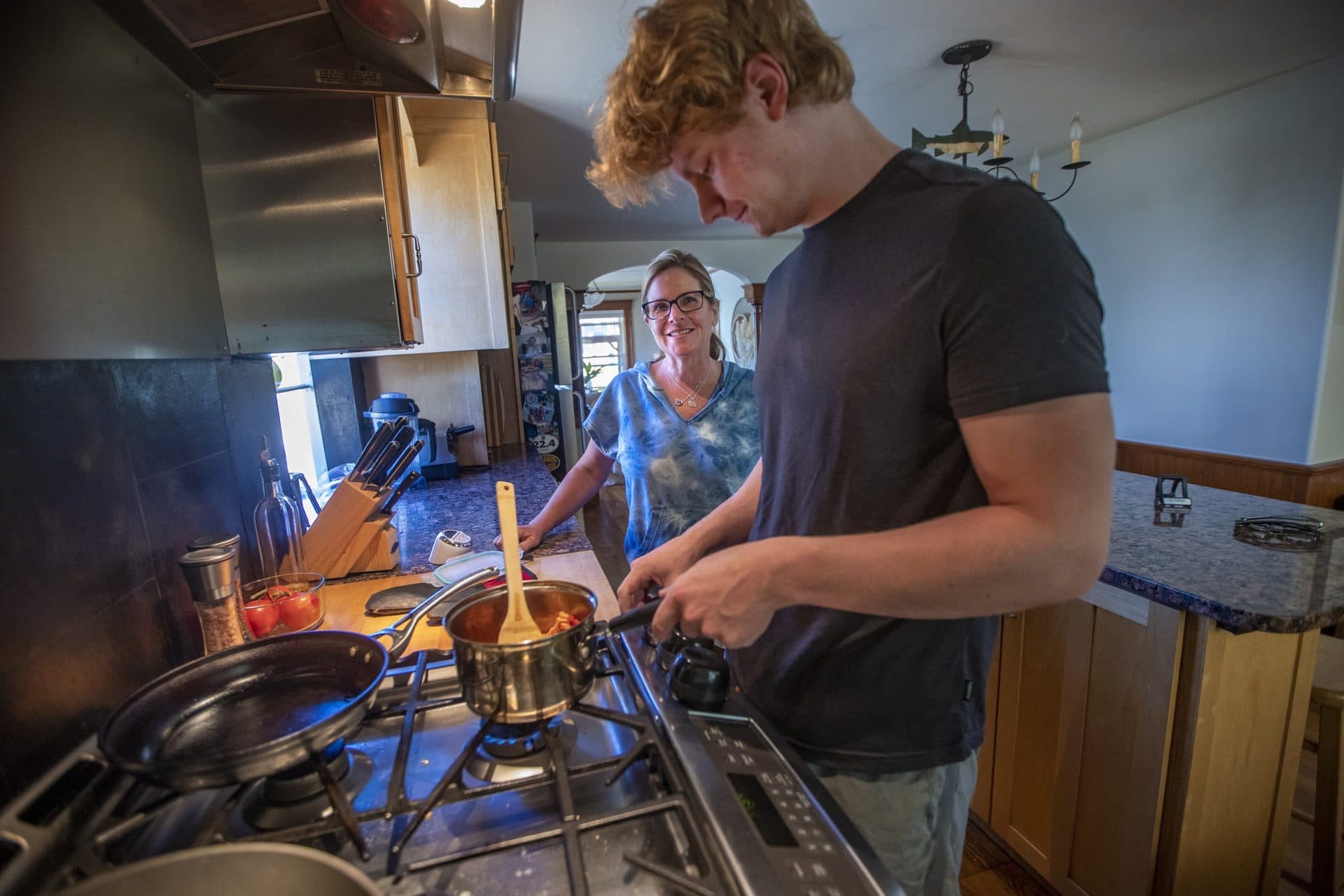 Karen Marmai speaks with her son Jackson as he prepares lunch on the stove top. (Jesse Costa/WBUR)