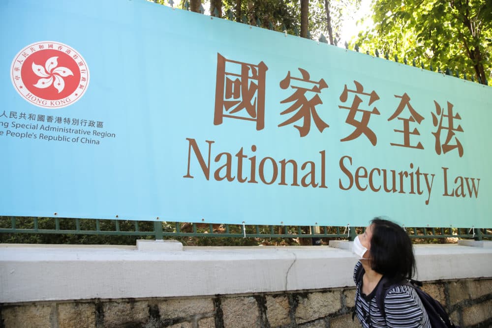 A woman walks past a promotional banner of the China's national security law in Hong Kong on June 30, 2020. (Kin Cheung/AP)