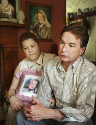 Magdalen Bish, left, holds a pillow with an image of her daughter, deceased lifeguard Molly Bish, while her husband and father of Molly, John Bish, right, speaks with reporters in their Warren home, in this 2003 file photo. On Thursday, prosecutors named Francis Sumner Sr. as a person of interest in the case. (AP Photo/Steven Senne)