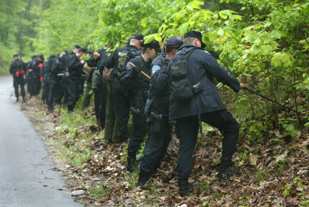 Massachusetts State Police Troopers and Environmental Police officers search in tight formation in this June 9, 2003 file photo, for evidence in the disappearance of Molly Bish. (Bill Greene/Pool Photo via AP, File)