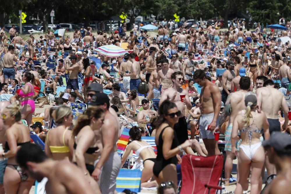 Crowds gather on L Street Beach on Saturday, June 5 in South Boston. New England has among the highest vaccination rates in the U.S. and is seeing sustained drops in COVID-19 cases, hospitalizations and deaths. (Michael Dwyer/AP)
