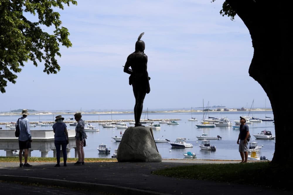 Visitors stand near a 1921 statue of the Wampanoag leader Massasoit on Cole's Hill, in Plymouth. (Steven Senne/AP)