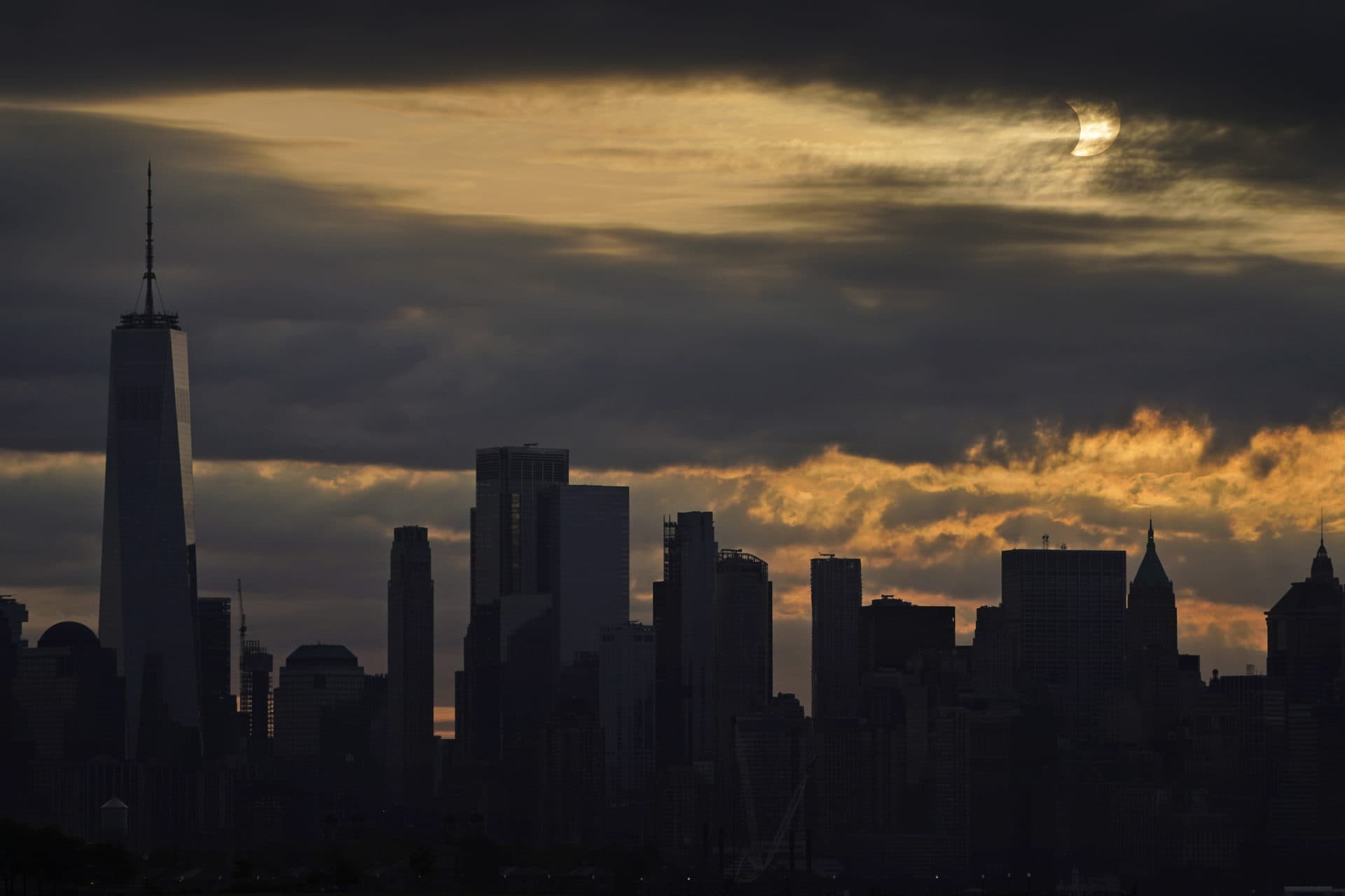 The sun is partially eclipsed as it rises over lower Manhattan in New York, Thursday. (Seth Wenig/AP)