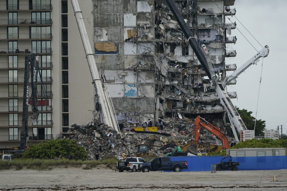 June 30, 2021: Search and rescue personnel work alongside heavy machinery to sift through the rubble at the Champlain Towers South condo building, where scores of people remain missing almost a week after it partially collapsed in Surfside, Fla. (Lynne Sladky/AP)