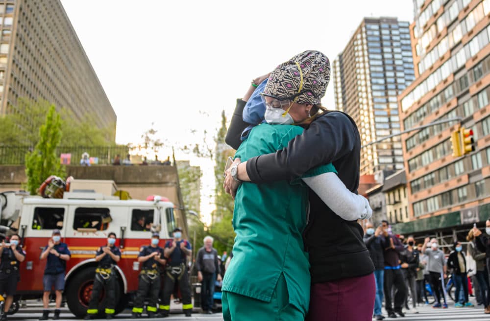 Medical workers hug outside NYU Langone Health hospital as people applaud to show their gratitude to medical staff and essential workers during the coronavirus pandemic on May 7, 2020 in New York City. (Noam Galai/Getty Images)