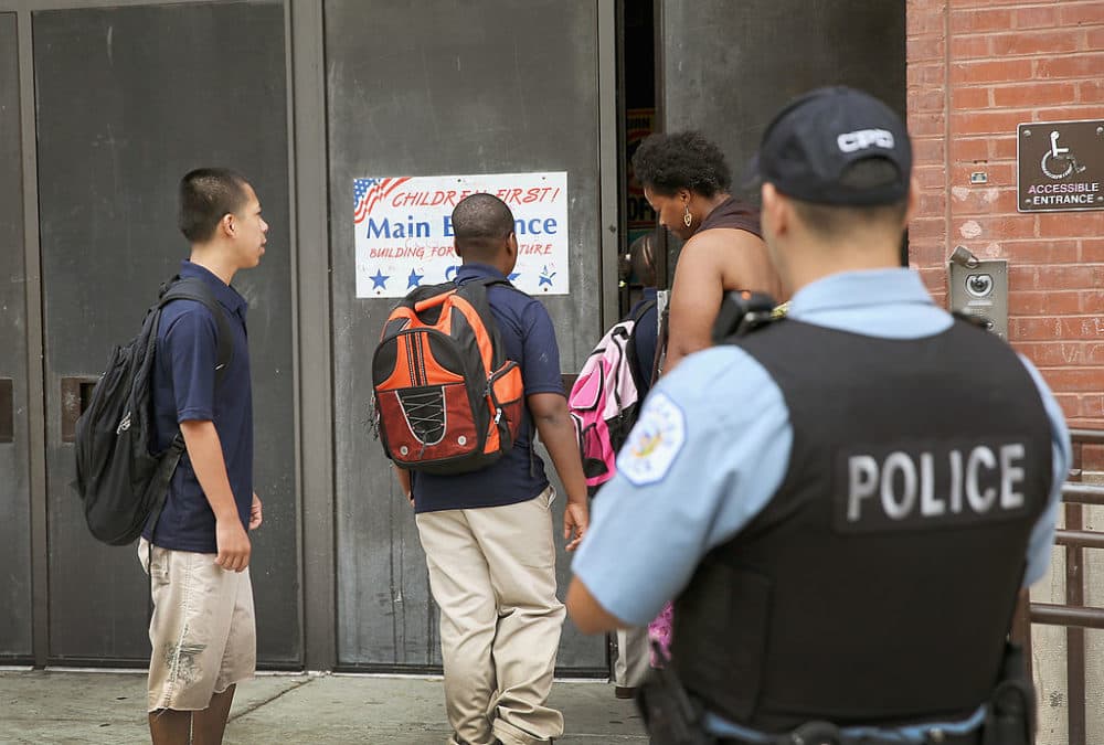 A probationary Chicago police officer watches as students arrive at Laura Ward Elementary School in Chicago, Illinois. (Scott Olson/Getty Images)
