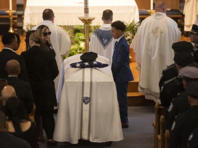 WORCESTER - Jennifer Familia, wife of fallen Worcester Police Officer Enmanuel Familia, stands next to his casket across from their son Jovan Familia during his funeral Mass at St. John Church in Worcester Massachusetts on Thursday, June 10, 2021. (ASHLEY GREEN / TELEGRAM & GAZETTE)