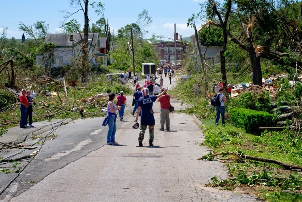Tornado survivors survey the damage along Washington Street in Monson. (Jesse Costa/WBUR)