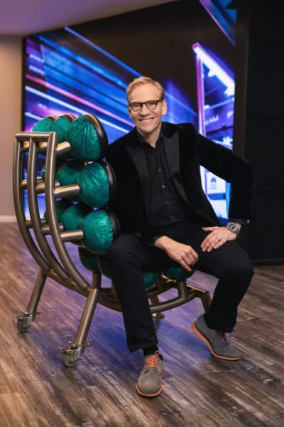 Artist John Carter sitting in his &quot;Spare Chair&quot; made out of bowling balls. (Courtesy Tamara Fleming)