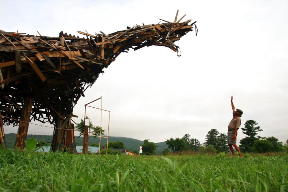 In this July 9, 2010, file photo Brian Boland, a former teacher, hot-air balloon designer and balloon pilot, stands with his "Vermontasaurus," a 25-foot tall oddity thrown together with scrap wood. (Alden Pellett/AP)
