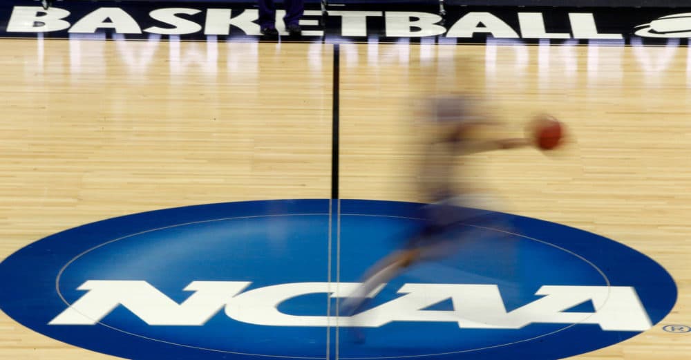 A player runs across the NCAA logo (Keith Srakocic/AP)