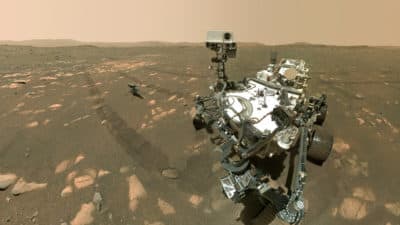 This April 6, 2021, image made available by NASA shows the Perseverance Mars rover, foreground, and the Ingenuity helicopter about 13 feet behind. This composite image was made by the WASTON camera on the rover's robotic arm on the 46th Martian day, or sol, of the mission. (NASA/JPL-Caltech/MSSS via AP)