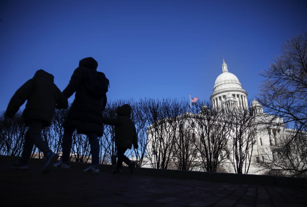 Pedestrians walk past the Rhode Island Statehouse. (David Goldman/AP)