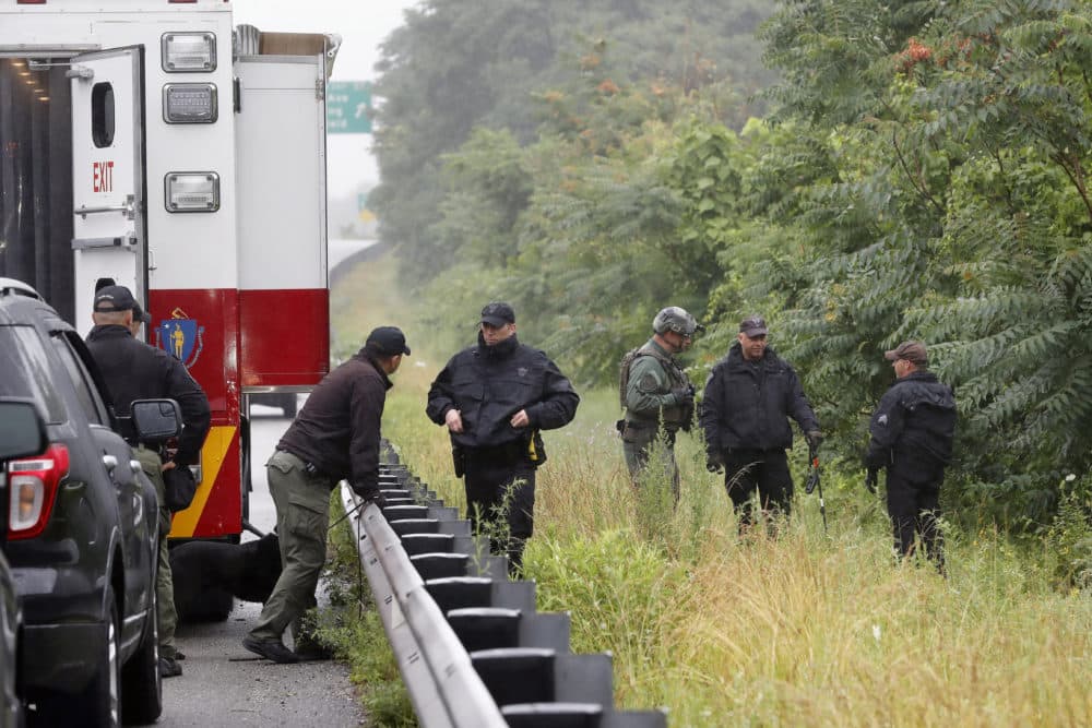 Police work in the area of an hours long standoff with a group of armed men that partially shut down I-95 on Saturday in Wakefield, Mass. (Michael Dwyer/AP)