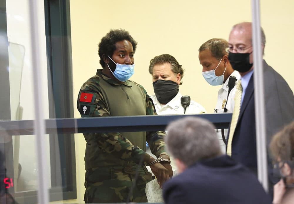 Quinn Cumberlander, left, one of 11 people charged in connection with an armed standoff on I-95 last weekend, appears during his arraignment at Malden District Court on Tuesday. (Suzanne Kreiter/The Boston Globe via AP, Pool)