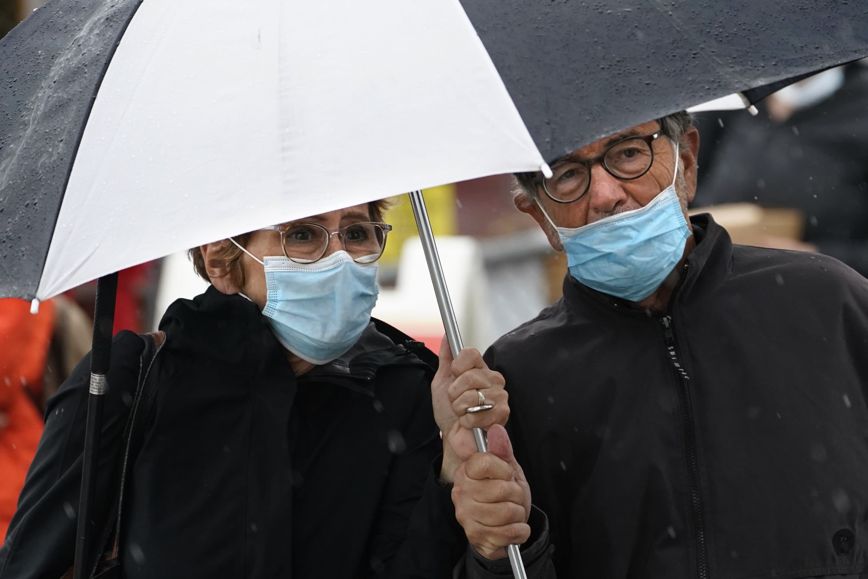 Joanne MacIsaac and Ron Delucia, of Medford share an umbrella, Friday, July 9, 2021, as the remnants of Tropical Storm Elsa arrive in Portland, Maine. Robert F. Bukaty/NPR)