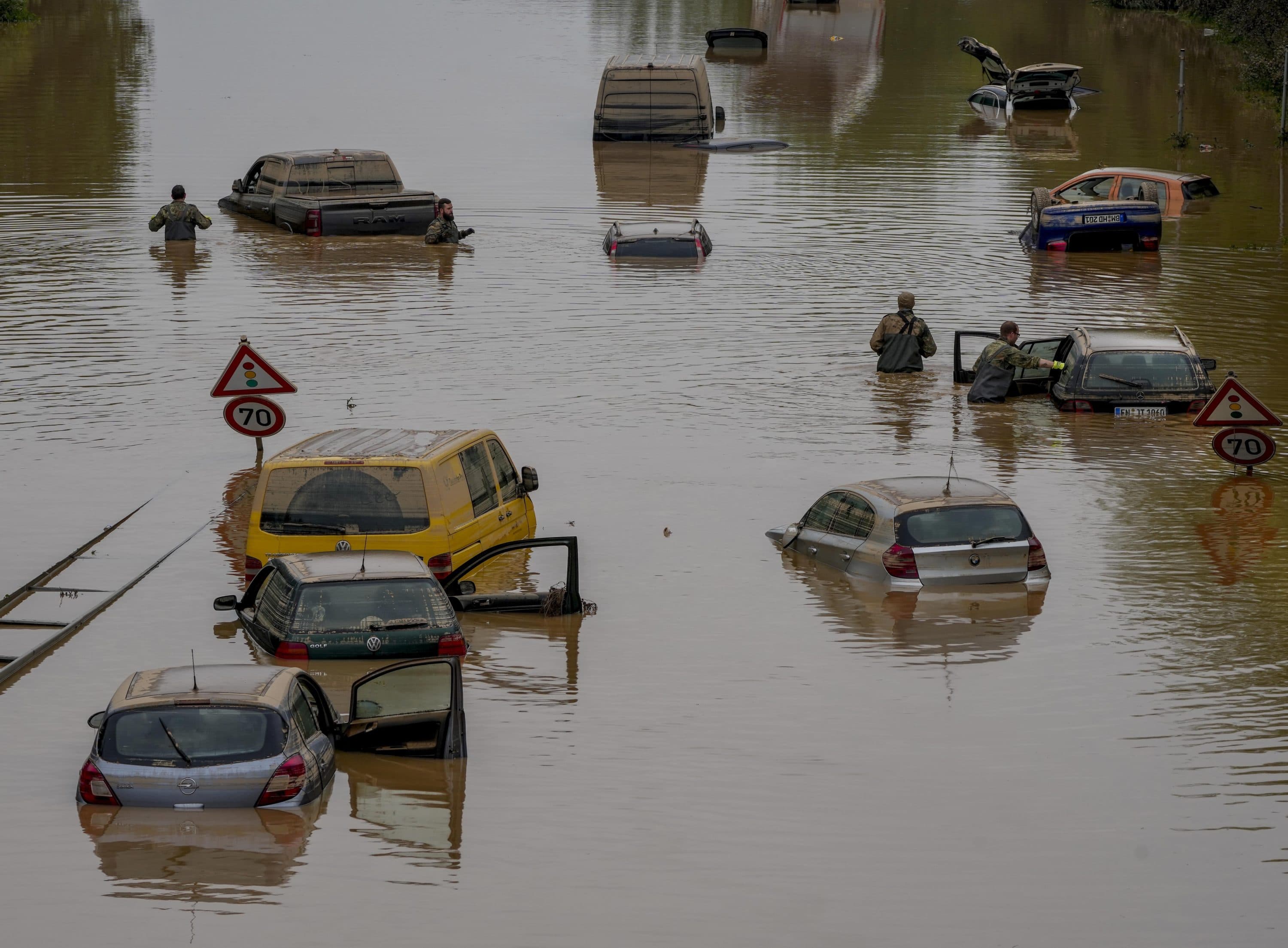 Helpers check for victims in flooded cars on a road in Erftstadt, Germany, on July 17, 2021. Due to strong rain falls, the small Erft river went over the banks causing massive damages. (Michael Probst/AP)
