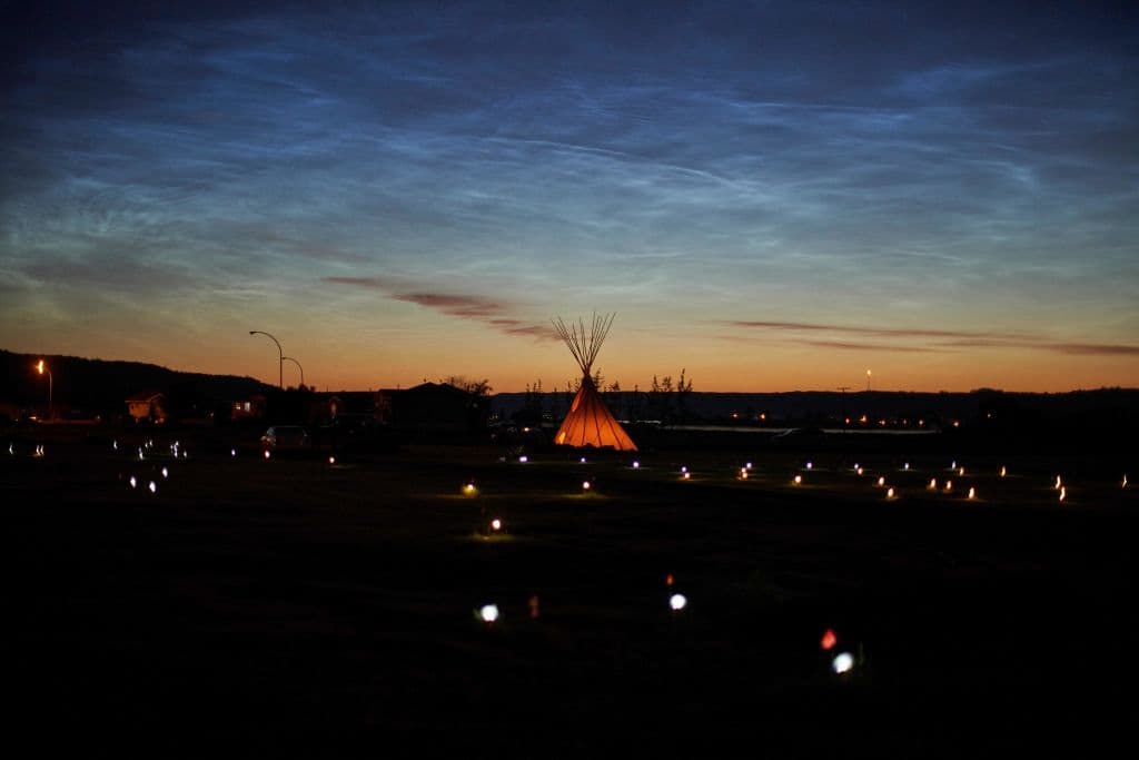 Solar lights and flags mark the spots where 751 human remains were recently discovered in unmarked graves at the site of the former Marieval Indian Residential School on the Cowessess First Nation in Saskatchewan on June 27, 2021. (Geoff Robins/AFP/Getty Images)
