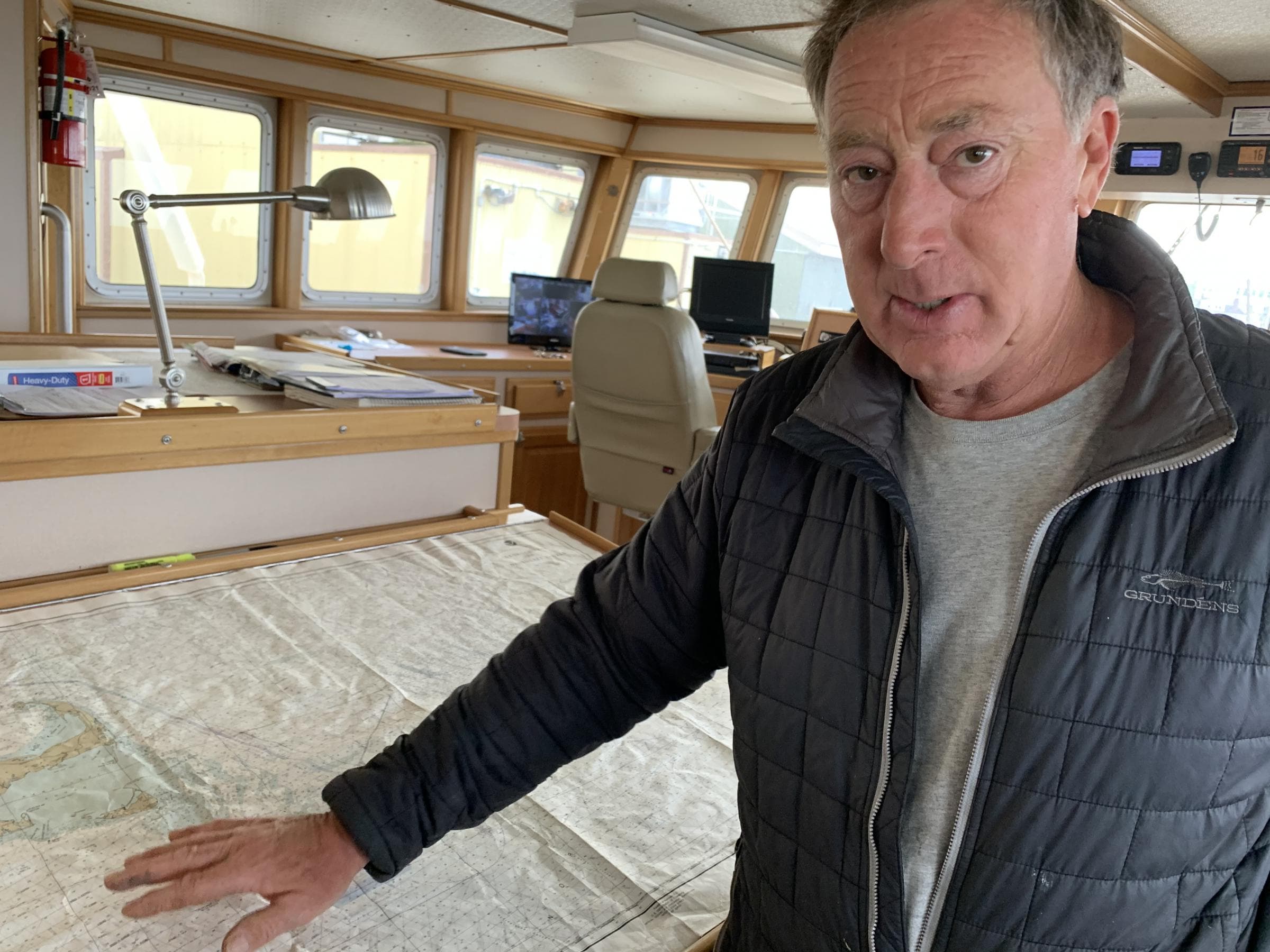 In the wheelhouse of the Furious, owner Joe Gilbert indicates where future planned wind farms will impact fishing grounds. (Harriet Jones/Connecticut Public Radio)
