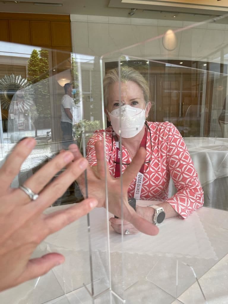 The author's wife, on assignment with NBC at the Olympics in Tokyo, behind plexiglass at dinner. (Courtesy E.M. Swift)