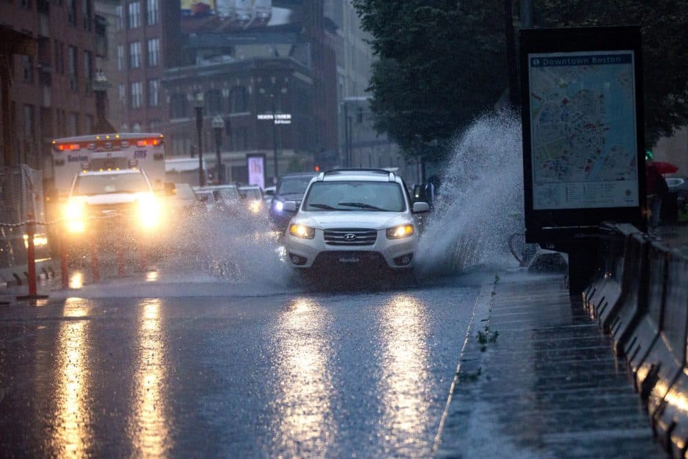 Cars drive through a flooded Stuart Street during the heavy rain from Tropical Storm Elsa on July 9, 2021. (Jesse Costa/WBUR)