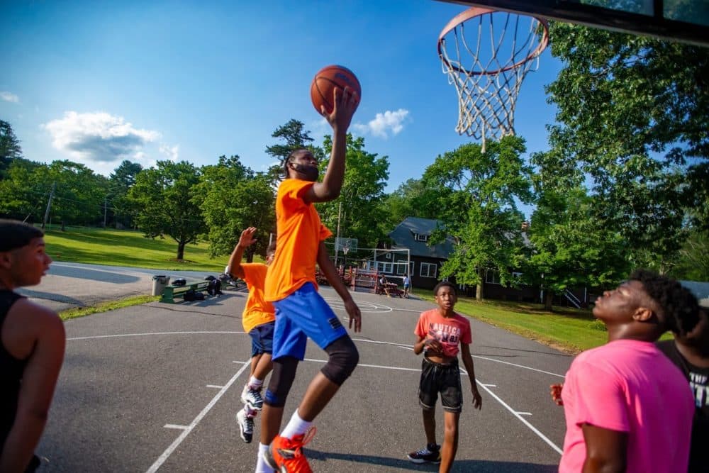 Joshua-Mark Campbell, 17, goes up for a layup while playing basketball with other boys at Camp Atwater. (Jesse Costa/WBUR)