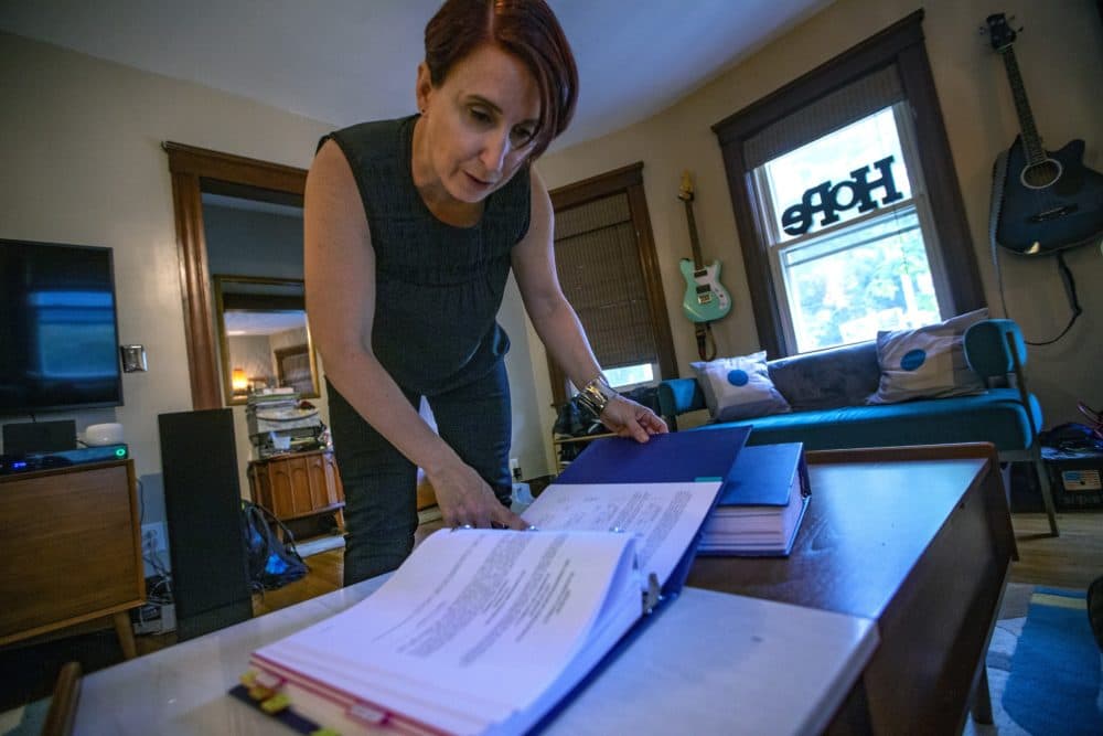 Kristin Johnson, a parent-advocate for a return to an elected school committee in Boston, leafs through binders full of documants she has collected about the history of the Boston School Committee. (Jesse Costa/WBUR)