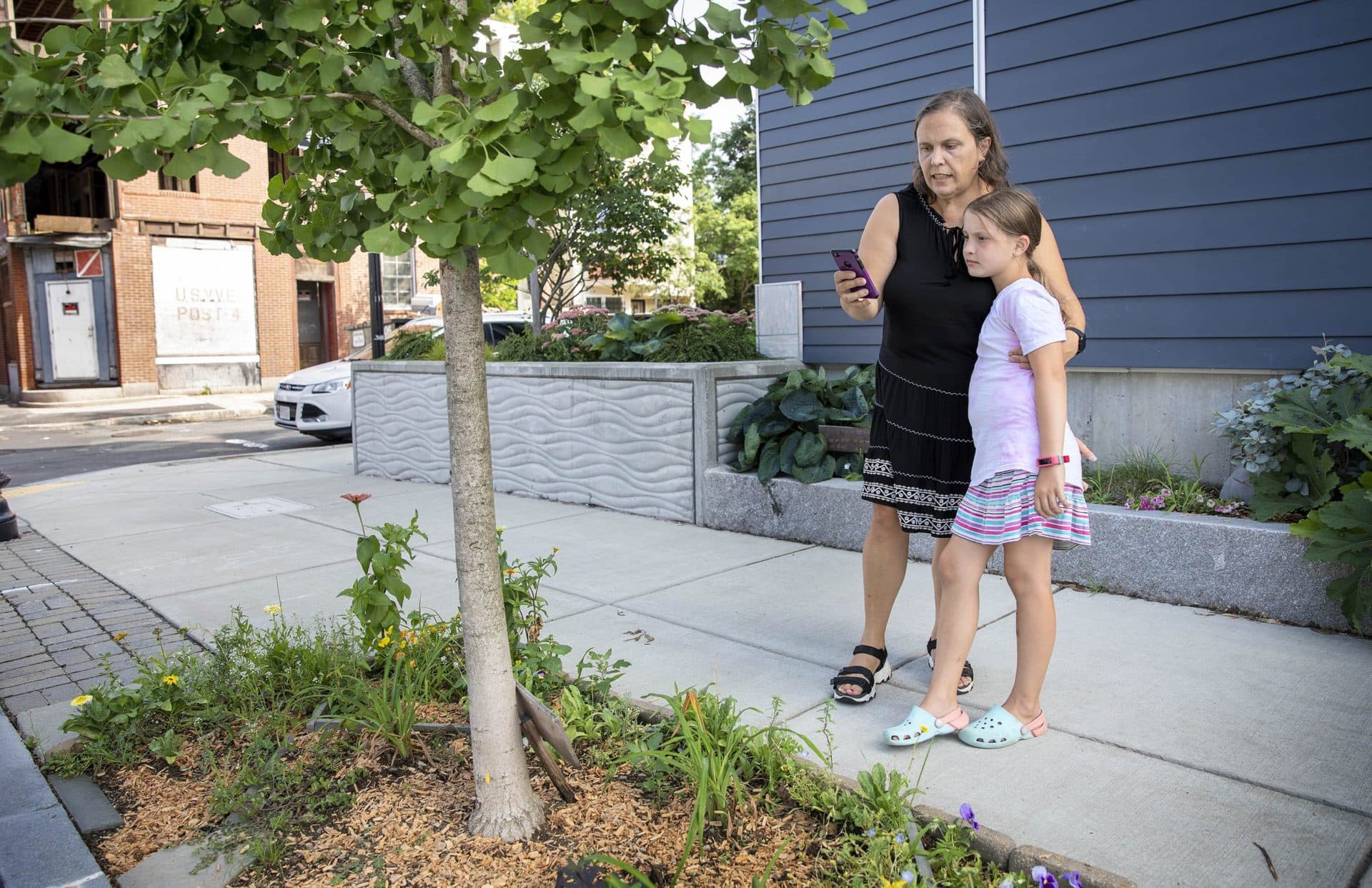Eugenia Corbo and her daughter, Maite, enter data about their chosen ginkgo tree in East Boston into the i-Tree app. (Robin Lubbock/WBUR)