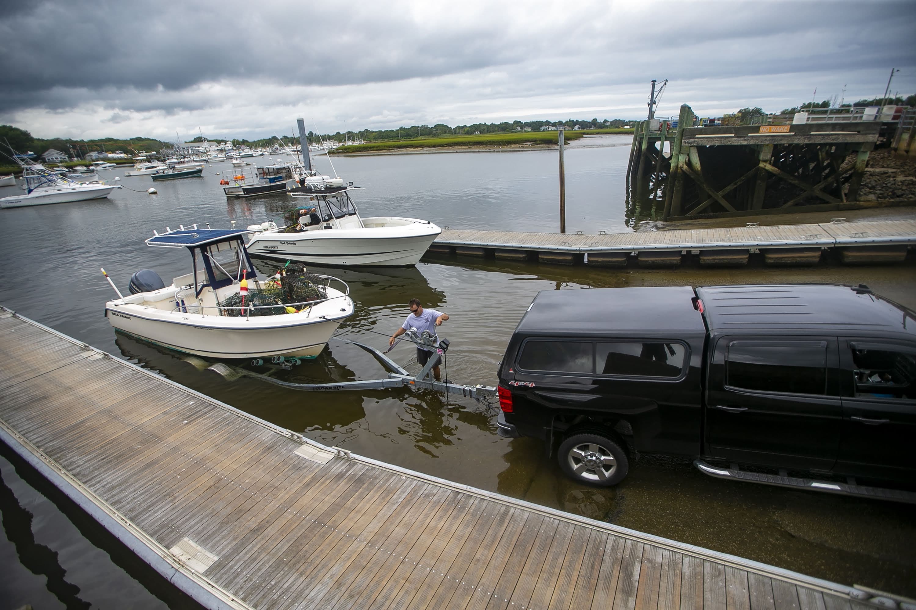 Lobstermen remove their traps and boats from Green Harbor in Marshfield due to the approach of Henri this weekend. (Jesse Costa/WBUR)