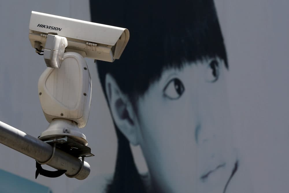 A video surveillance camera made by China's Hikvision is mounted on top of a street near a advertisement poster in Beijing, Thursday, May 23, 2019. (Andy Wong/AP)