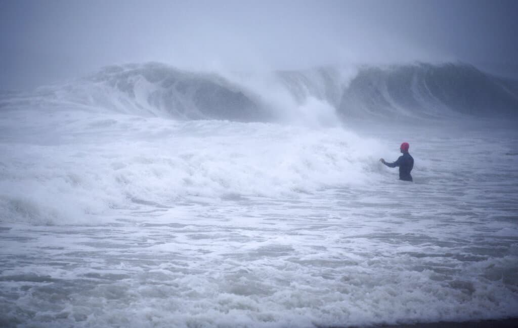 Matt Prue, from Stonington, Connecticut, walks out into the Atlantic Ocean to body surf the waves from Tropical Storm Henri as it approaches Westerly, Rhode Island on Sunday. (Stew Milne/AP)