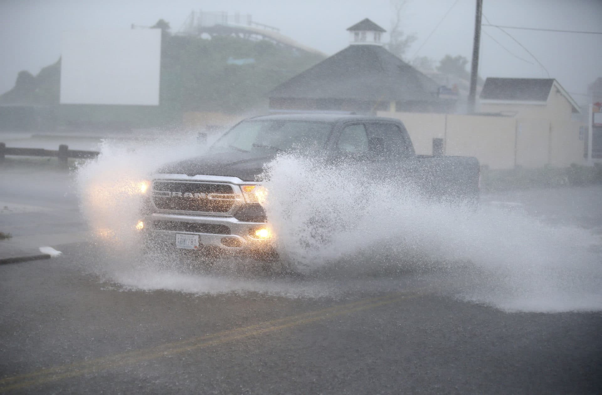 A truck drives through a flooded Atlantic Ave in Westerly, R.I., as the storm approaches. (Stew Milne/AP)