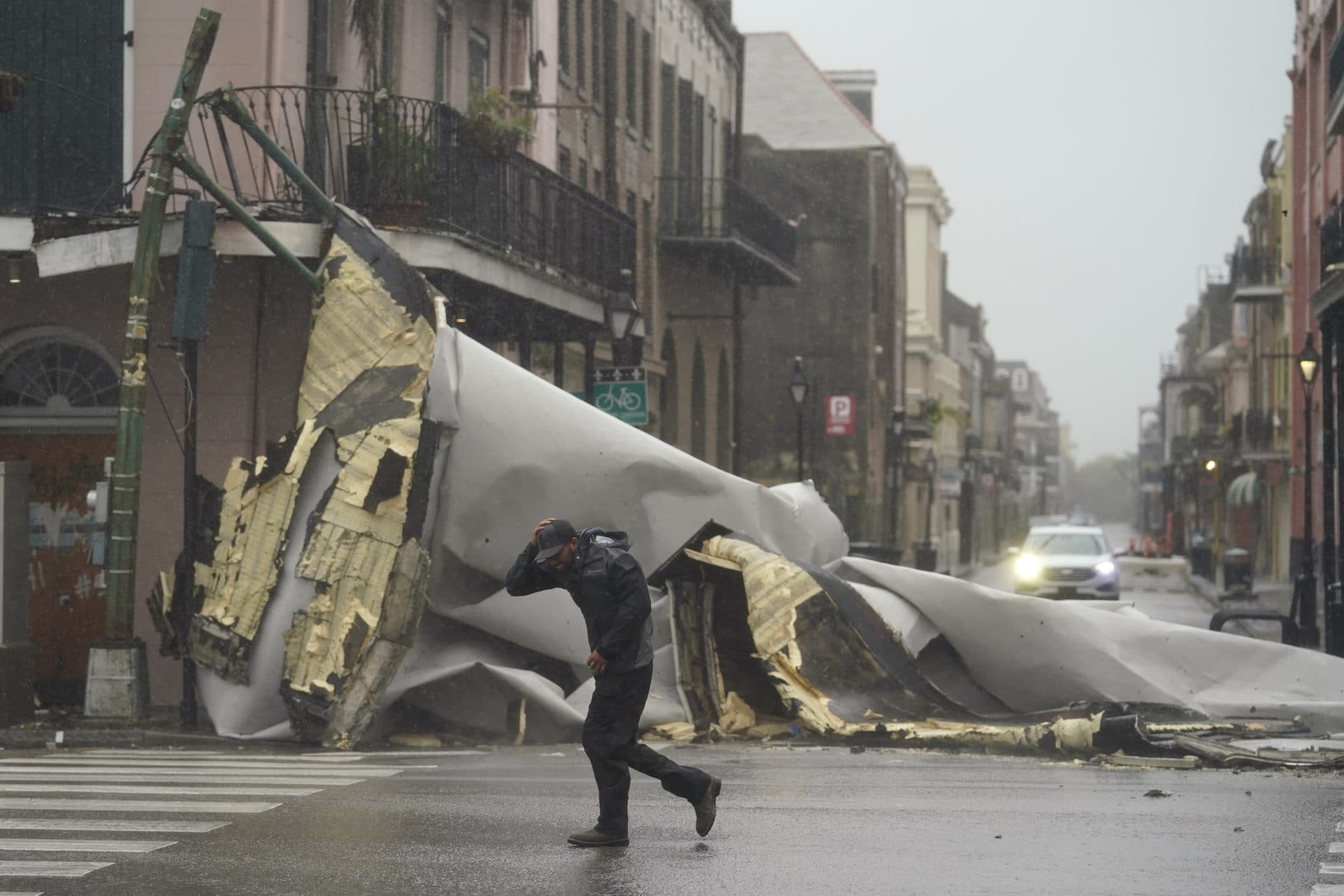A man passes by a section of roof that was blown off of a building in the French Quarter by Hurricane Ida winds, Sunday, Aug. 29, 2021, in New Orleans. (Eric Gay/AP Photo)