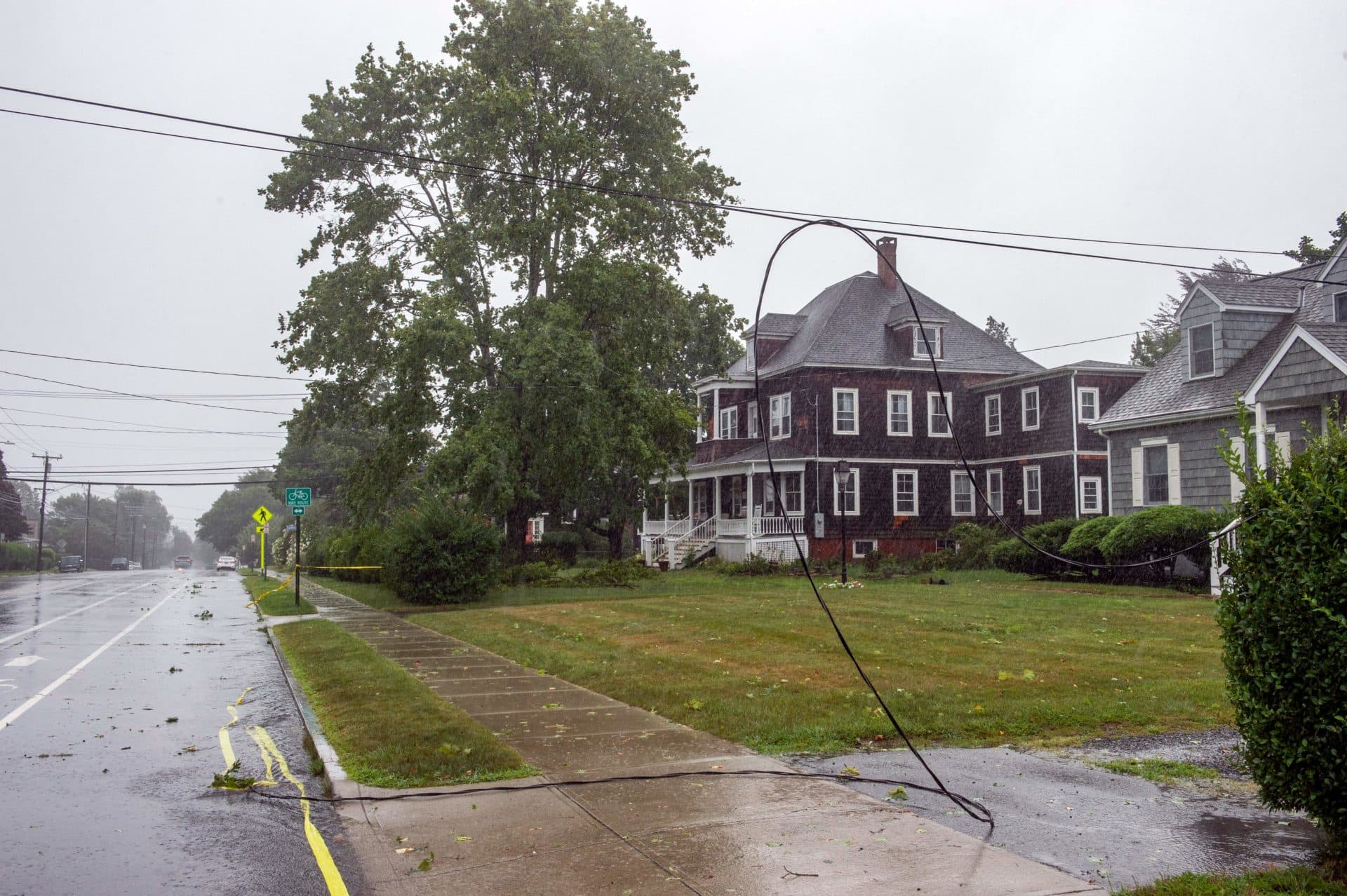 A power line hangs onto the road after being broken from a home when a tree fell onto it during Tropical Storm Henri in New London, Connecticut. (Joseph Prezioso/AFP via Getty Images)