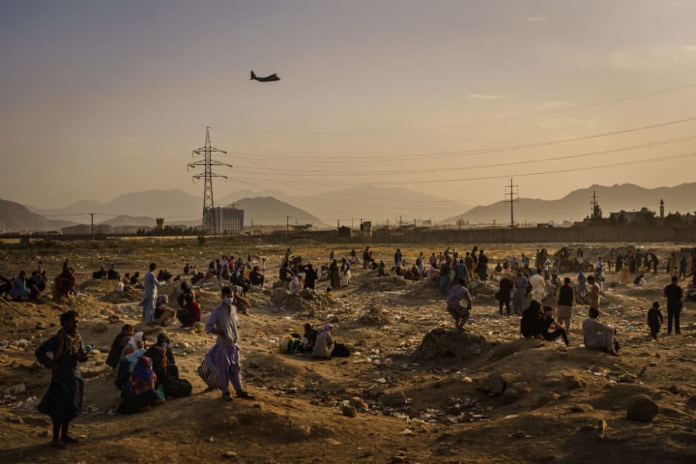A military transport plane launches off while Afghans who cannot get into the airport to evacuate, watch and wonder while stranded outside, in Kabul, Afghanistan, Monday, Aug. 23, 2021. (Marcus Yam / Los Angeles Times via Getty Images)