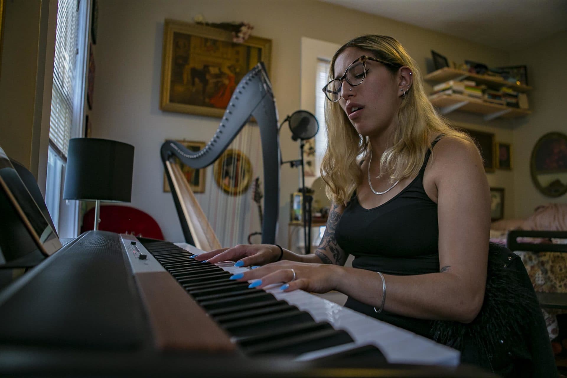 Haydee Irizarry plays an electric keyboard at her home. (Jesse Costa/WBUR)