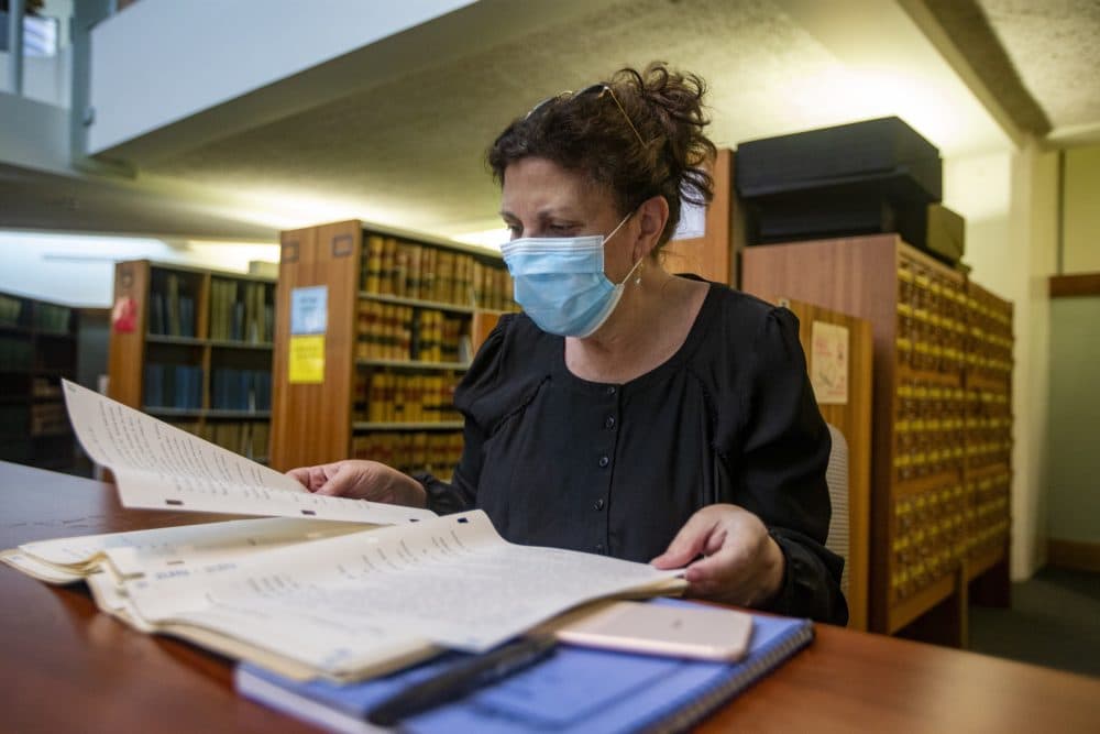 Laura Zigman flips through old administrative documents from the Fernald School in Waltham at the state archives. (Jesse Costa/WBUR)