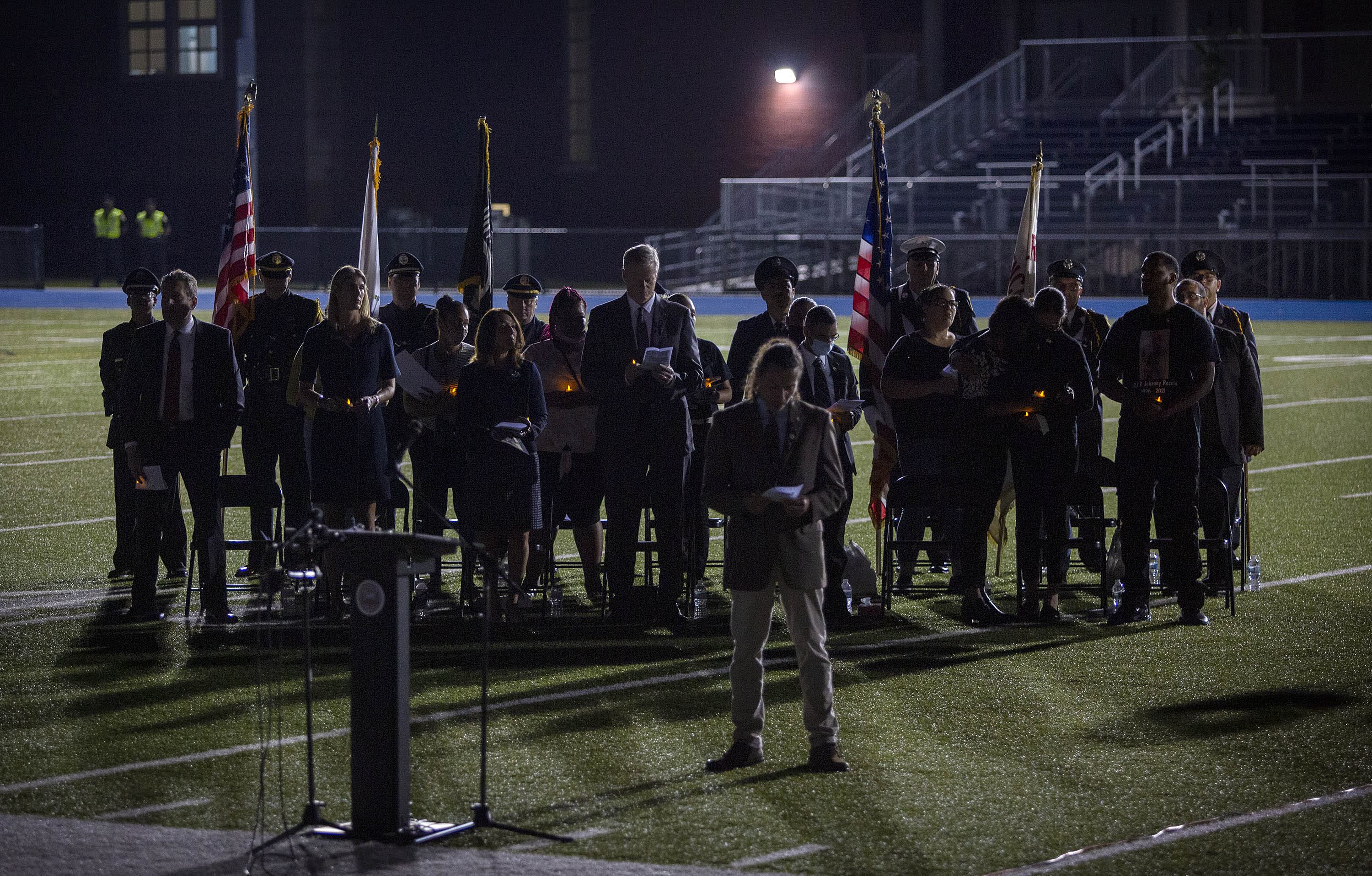 Gov. Charlie Baker and U.S. Rep. Lori Trahan with family members and the color guard at the vigil. (Robin Lubbock/WBUR)