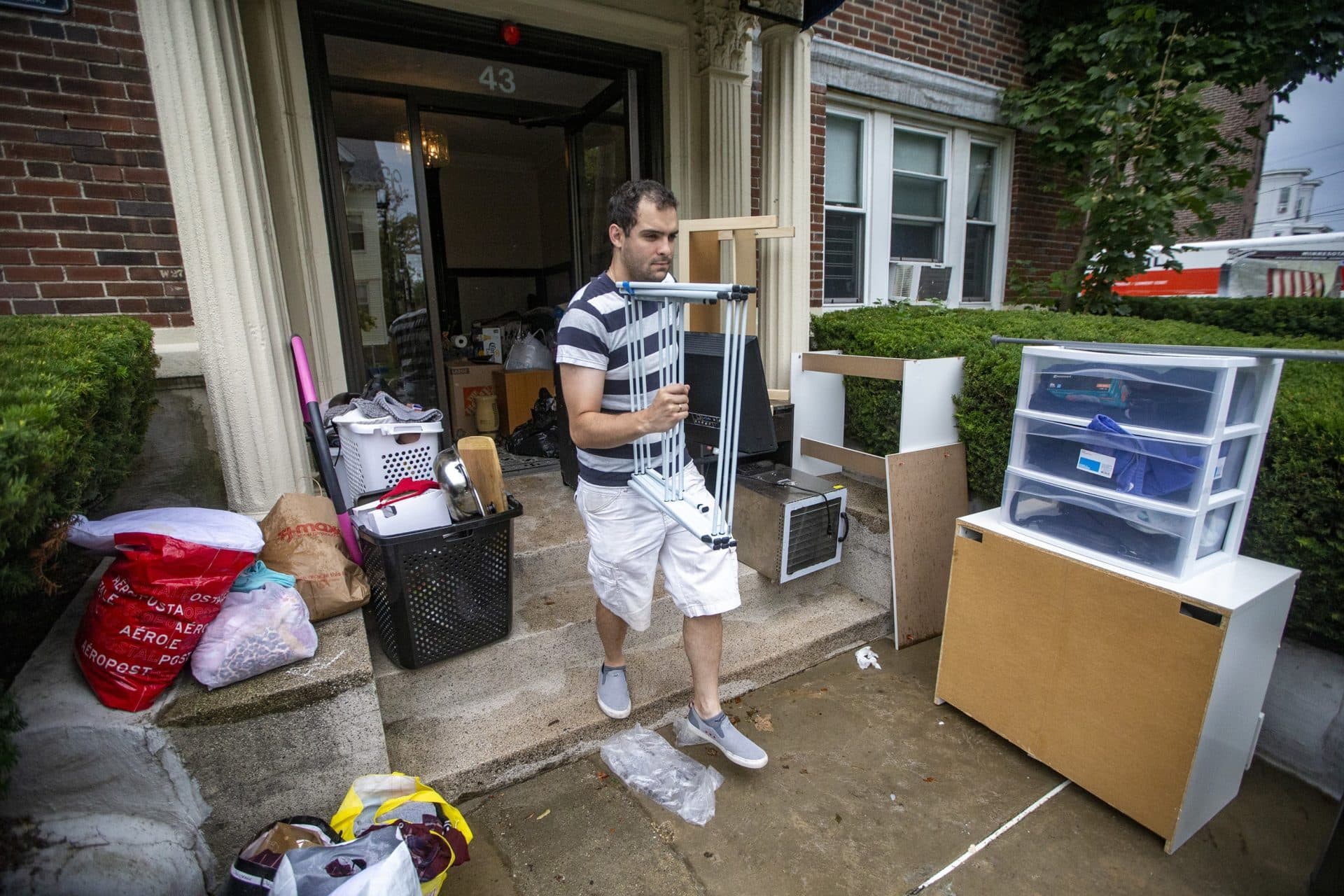 A man moves his belongings out of an apartment building on Linden Street in Allston on Sept. 1. (Jesse Costa/WBUR)