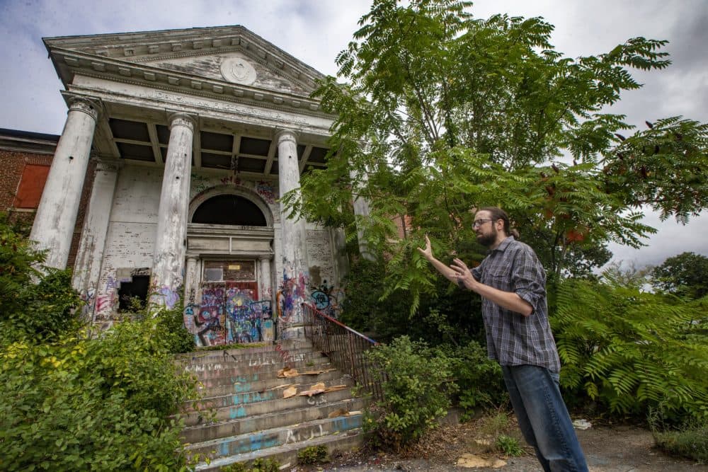 Alex Green describes the grand columned entryway of the Dr. William F. McLaughlin administration building, the last dilapidated building left of the former Metropolitan State Hospital in Waltham. (Jesse Costa/WBUR)