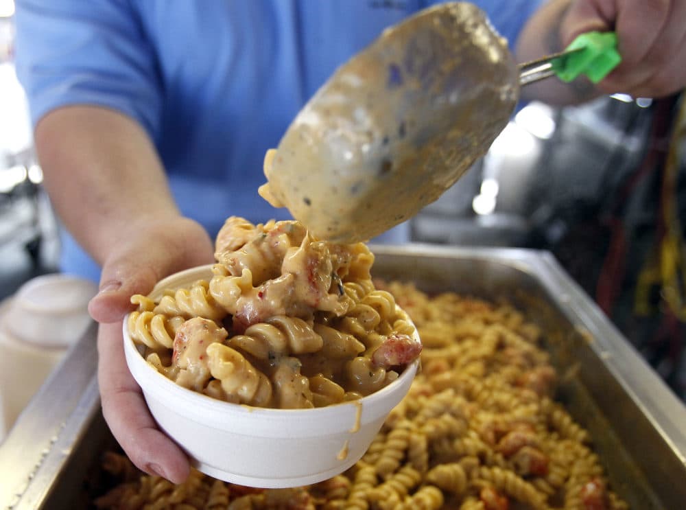 Justin Anderson scoops a helping of Crawfish Monica into a bowl before serving it at the New Orleans Jazz and Heritage Festival in New Orleans, Sunday, May 8, 2011. (Patrick Semansky/AP)
