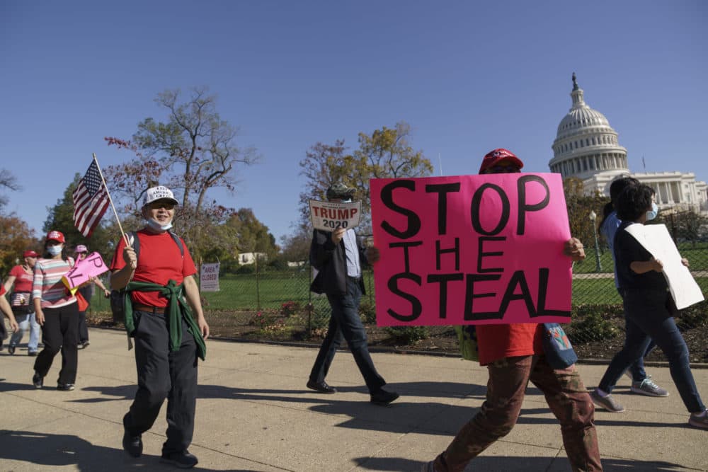 Supporters of President Donald Trump carry flags and signs as they parade past the Capitol in Washington. (AP Photo/J. Scott Applewhite)