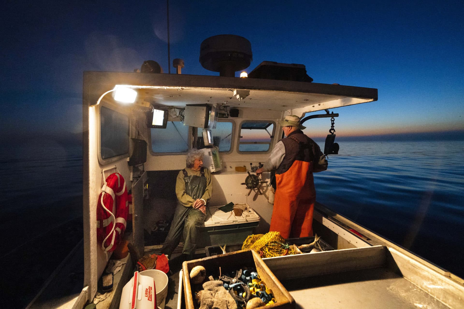 Virginia Oliver, left, chats with her son Max Oliver while heading out to sea to fish for lobster at dawn. (Robert F. Bukaty/AP)