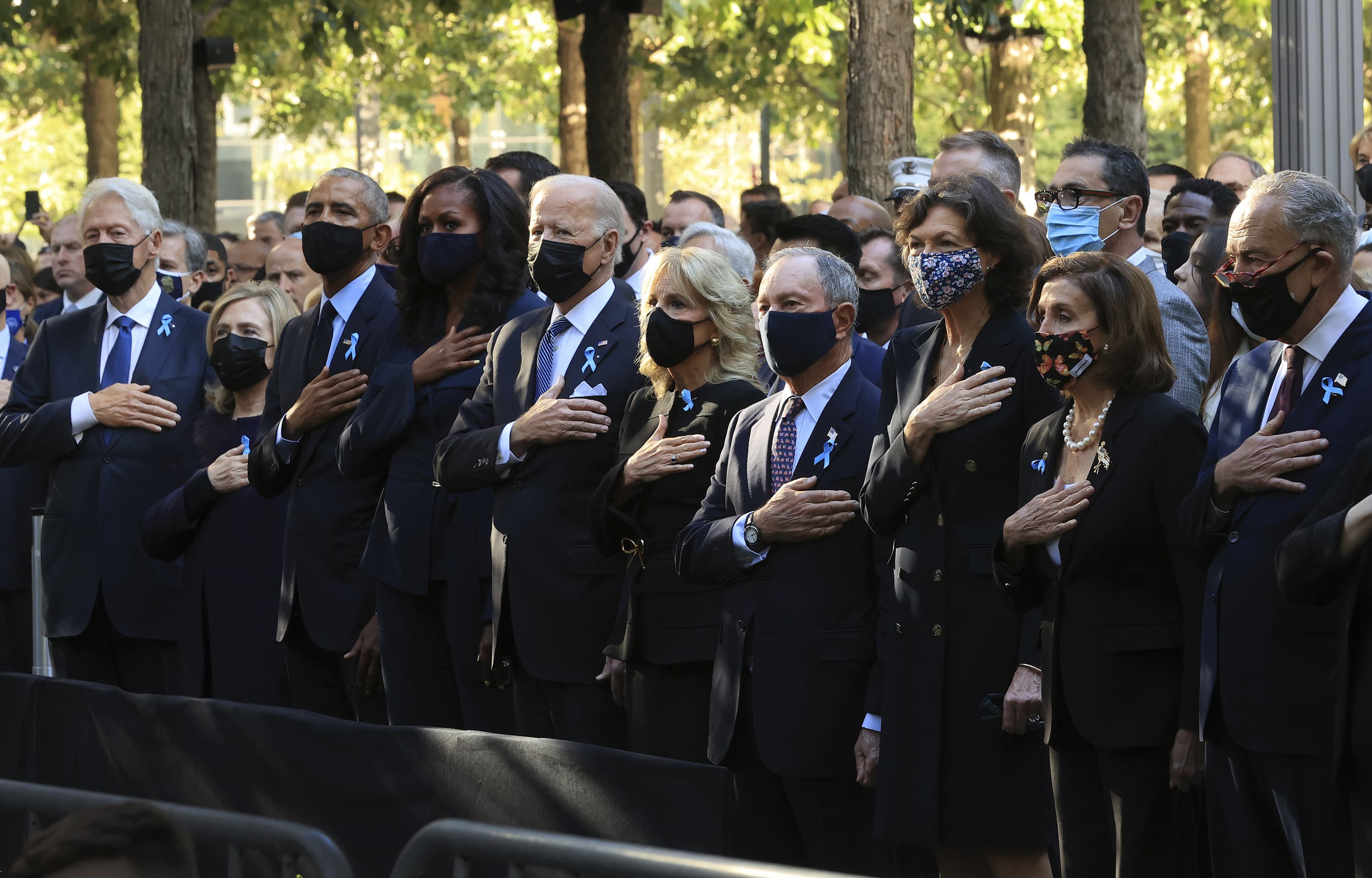 From left, former President Bill Clinton, former First Lady Hillary Clinton, former President Barack Obama, former First Lady Michelle Obama, President Joe Bien, First Lady Jill Biden, former New York City Mayor Michael Bloomberg, Bloomberg's partner Diana Taylor, Speaker of the House Nancy Pelosi (D-CA) and Senate Minority Leader Charles Schumer (D-NY) stand for the national anthem during the annual 9/11 Commemoration Ceremony at the National 9/11 Memorial and Museum on Saturday, Sept. 11, 2021 in New York. (Chip Somodevilla/Pool Photo via AP)