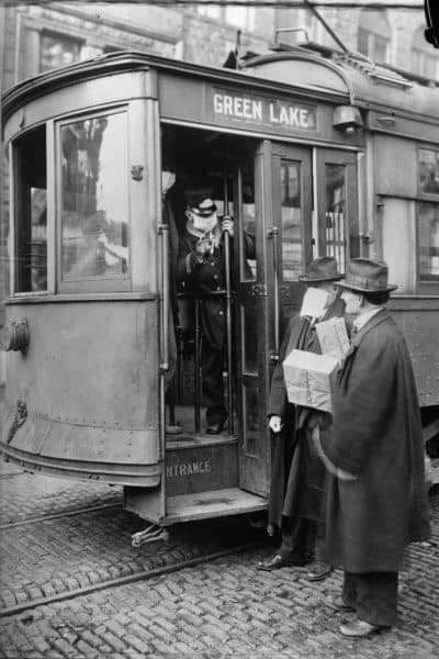 A conductor checks to see if potential passengers are wearing masks in Seattle during the influenza epidemic. (Library of Congress via AP)