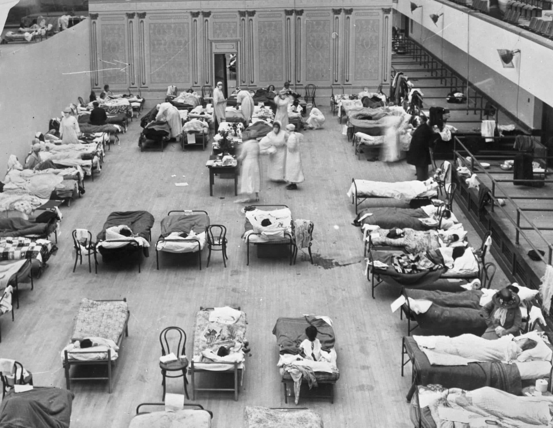 Volunteer nurses from the American Red Cross tend to influenza patients in the Oakland Municipal Auditorium, used as a temporary hospital in 1918-1919. (Edward A. &quot;Doc&quot; Rogers/Library of Congress via AP)