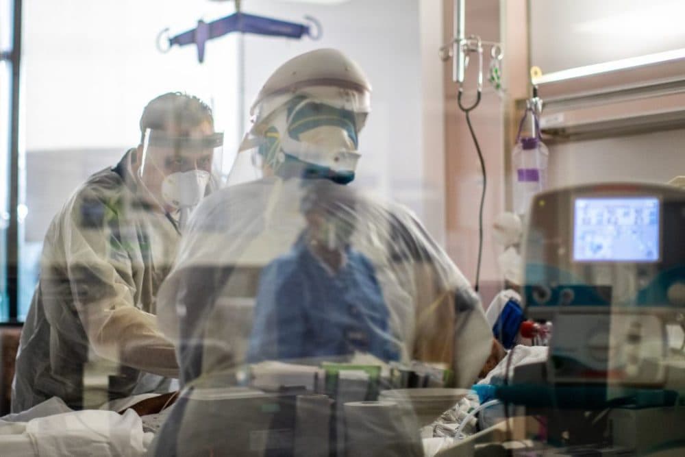 Doctor Thomas Yadegar (L) wears personal protective equipment (PPE) while he cares for a COVID-19 patient in the Intensive Care Unit (ICU) at Providence Cedars-Sinai Tarzana Medical Center in Tarzana, California on December 18, 2020. (Apu Gomes/ AFP)