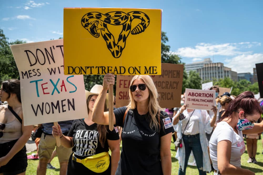 Protesters hold up signs at a protest outside the Texas state capitol on May 29, 2021 in Austin, Texas.  (Sergio Flores/Getty Images)