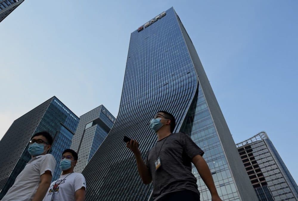 People walk in front of the Evergrande headquarters in Shenzhen, China's southern Guangdong province on September 15, 2021. (Noel Celis /Getty Images)