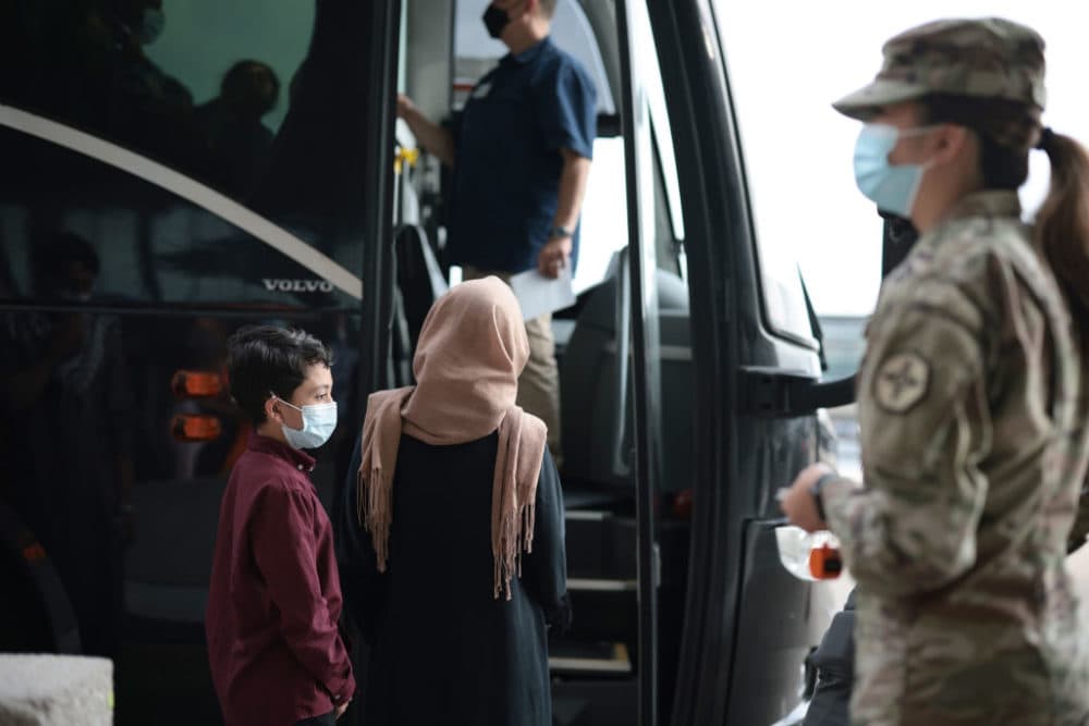 Refugees board a bus at Dulles International Airport in Virginia that will take them to a refugee processing center after being evacuated from Kabul following the Taliban takeover of Afghanistan on Aug. 31, 2021. (Anna Moneymaker/Getty Images)